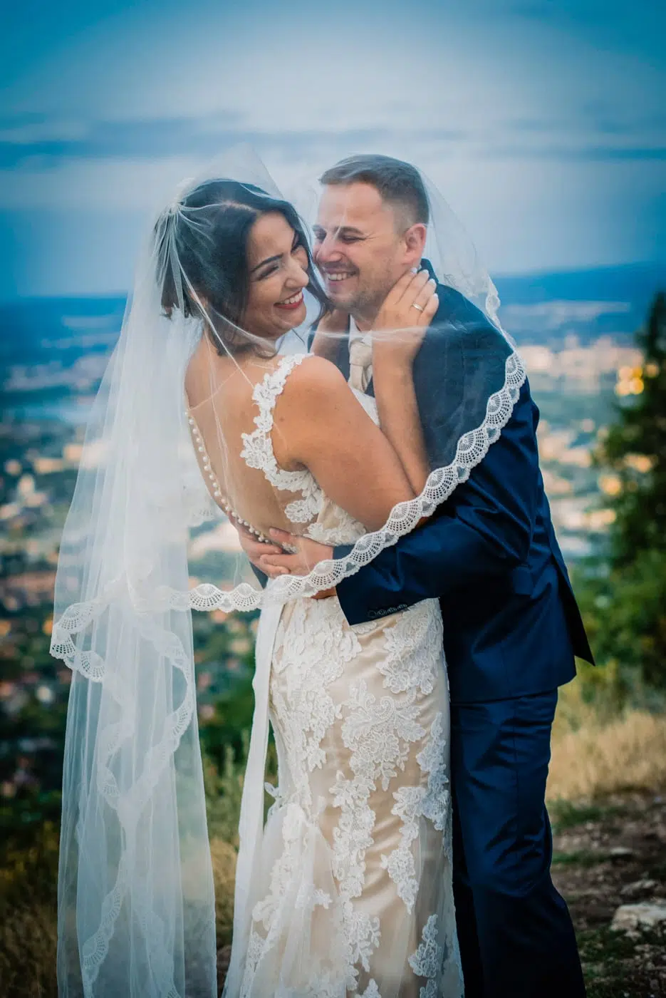 wedding couple snuggle on a wedding portrait session above the city at Three Border Mountain