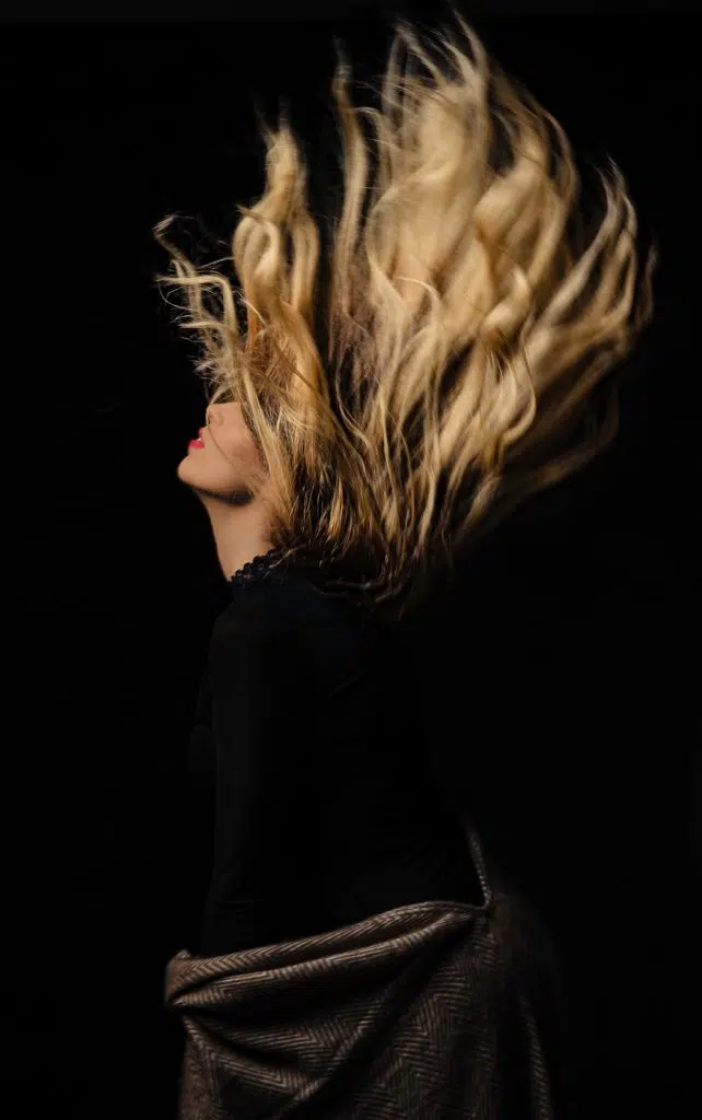 model is waving her hair artistically on a studio photoshoot